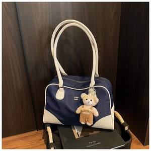 Détail du sac bowling en nylon bleu marine avec bordure blanche et breloque ourson