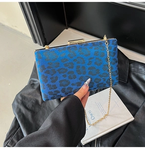 Dettaglio borsa blu leopardata con cornice dorata e tracolla a catena sottile