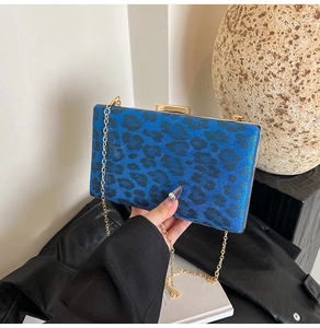 Dettaglio della borsa clutch rigida con stampa leopardata blu e catena dorata