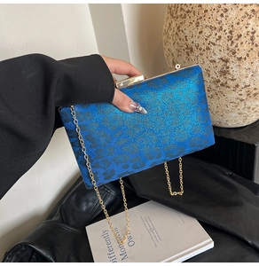 Dettaglio borsa da sera con stampa leopardata blu, catena dorata e chiusura in metallo chic