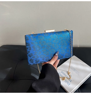 Dettaglio della borsa blu con stampa leopardata, cornice dorata e catenella