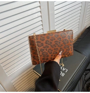 Dettaglio borsa da sera leopardata con tracolla a catena d'oro e chiusura in metallo