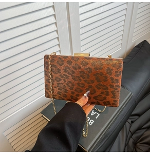 Dettaglio pochette rigida leopardata con chiusura e tracolla a catena dorata