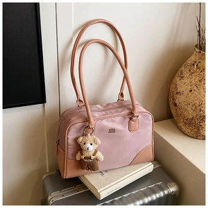 Détail du sac bowling en nylon mauve avec garniture contrastée et charm ours en peluche