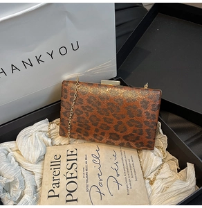 Dettaglio della borsa leopardata con catena dorata in una confezione regalo di lusso