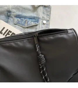 Close-up of smooth metal zipper and waterproof matte fabric on black crossbody bag