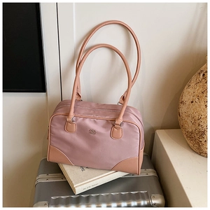 Vue détaillée du sac bowling en nylon rose avec détails en cuir brun et logo en métal