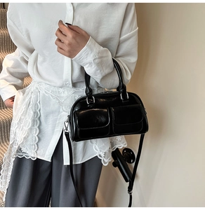 Fashionable black glossy crossbody bag featuring two functional front flap pockets