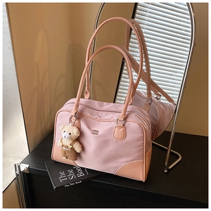 Détail du sac Boston en nylon rose avec garniture orange et pendentif d'ours en peluche