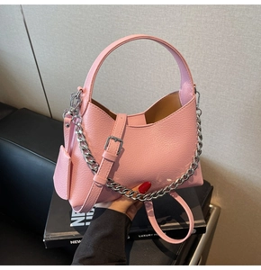 Detailed view of pink lychee texture leather bucket bag with silver chain and strap