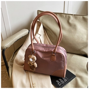 Détail d'un sac bowling en nylon avec accents en cuir et un charmant porte-clés ours