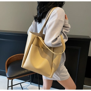 Detailed side view of large capacity cream tote bag with front pocket and slim shoulder strap