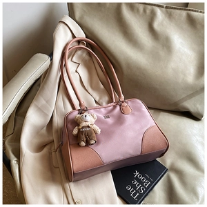 Détail du sac à main rose et marron avec pendentif ours en peluche et fermeture éclair