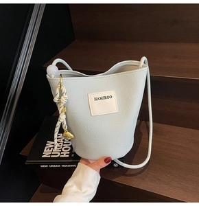 Détail du sac seau vert menthe avec texture litchi, logo HAMIROO et charme élégant