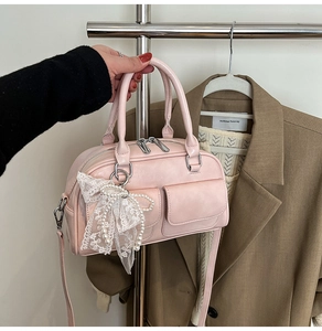 Detail of pink bowling handbag with white lace bow, pearl charm and silver hardware