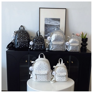 Trois sacs à dos à fleurs en noir, argent et blanc avec pendentifs peluche en rayon