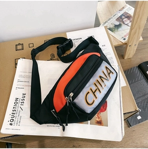 Dettaglio borsa a tracolla in nylon impermeabile con design a blocchi di colore e scritta CHINA