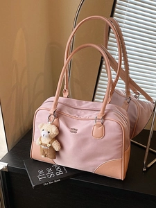 Sac Boston rose en nylon avec finitions cuir et breloque ours sur des livres