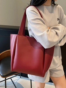 Minimalist large capacity dark red leather tote bag for women showing shoulder carry style