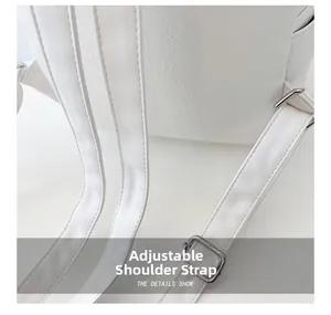 Détail des bretelles réglables avec boucles en métal argenté sur un sac à dos blanc