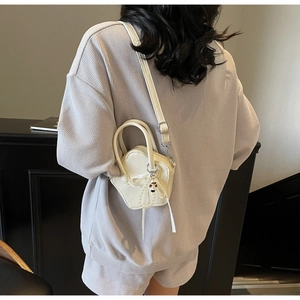 Cream star-shaped crossbody bag with pearl chain and bow detail on waffle texture suit