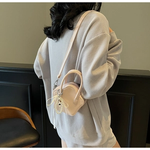 Detail of mini star bag with soft PU leather texture, ribbon bow, and pearl charm detail