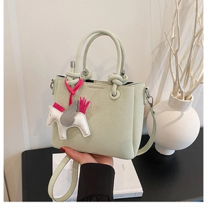 Detail of mint green bucket bag featuring lychee grain leather and silver hardware accents