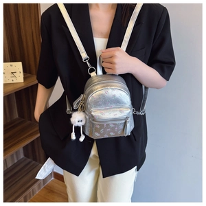Détail du mini sac à dos argenté métallisé à fleurs avec fermeture éclair et breloque