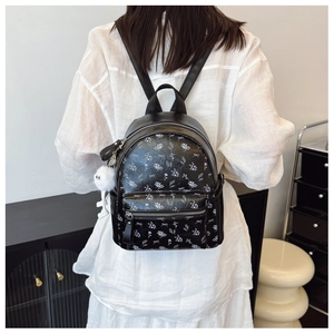 Détails du mini sac à dos noir en similicuir avec motifs floraux et pompon en peluche