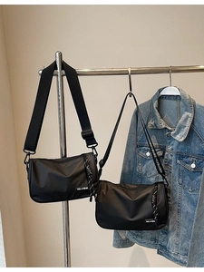 Minimalist black nylon crossbody messenger bag with adjustable shoulder strap and logo
