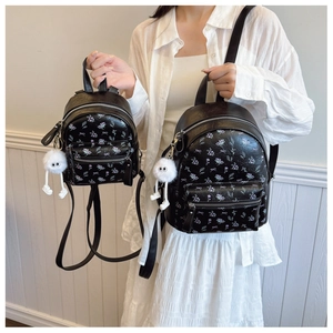 Détails de sacs à dos à fleurs noires avec nœuds violets et pompons en peluche