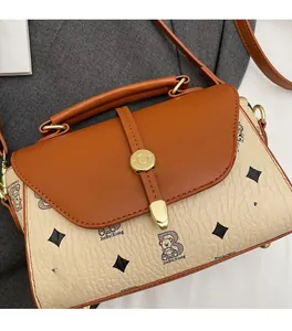 Detail of vintage beige handbag with teddy bear print and golden metal buckle