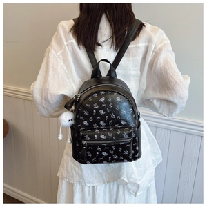 Gros plan d'un mini sac à dos floral avec imprimés papillons et pendentif en peluche