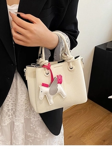 Fashionable cream white bucket bag with a decorative horse pendant and top handles