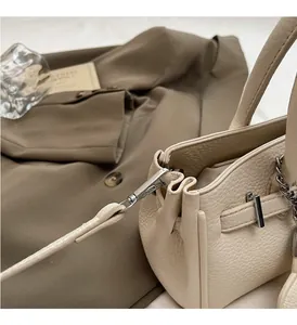 Close-up of premium lychee grain leather handbag with silver metallic lock and hardware