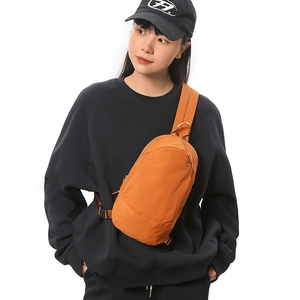 Detail of caramel orange crescent crossbody bag with durable nylon and wide strap buckle