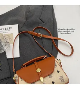 Detail of vintage printed handbag showing adjustable shoulder strap on gray blazer
