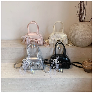 Detail view of ruched Boston handbags in pink, silver, black and beige with pearl charms