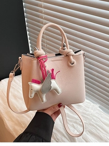 Light pink pebbled leather bucket bag with white horse charm and adjustable strap