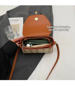 Detail of crossbody bag interior showing dual compartments and brown monogram pattern