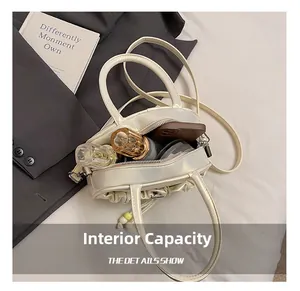 Internal capacity of pleated beige Boston bag with phone and perfume items