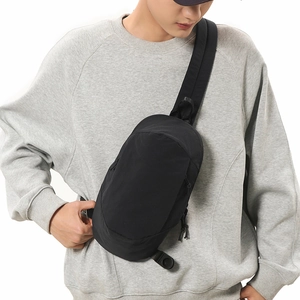 Water-resistant black nylon crossbody bag on model showing fit and compact size