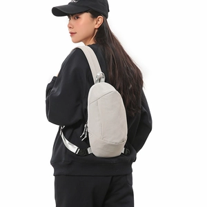 Light gray waterproof nylon sling bag for outdoor travel shown on a model