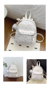 Détail d'un mini sac à dos à fleurs avec nœuds roses et porte-clé pompon en peluche