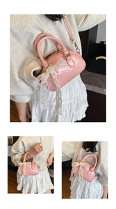 Detail of pink patent leather Boston bag featuring lace bow and embossed patterns