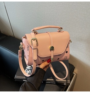 Detailed close-up of pink crossbody bag with litchi texture and gold hardware lock