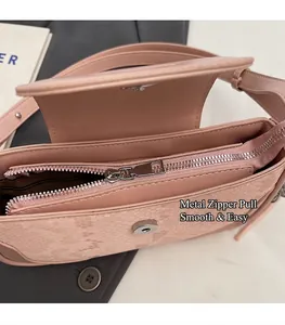 Detail of pink snake-pattern handbag showing smooth silver zipper and interior lining
