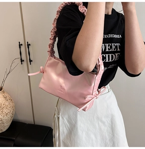 Dettaglio borsa sottobraccio in raso rosa con fiocco decorativo e logo Moon Shark