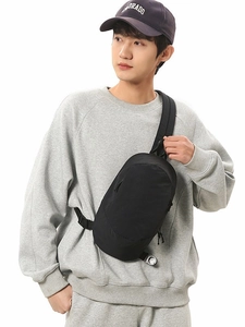 Lightweight black nylon crossbody bag for outdoor travel worn across the chest on a model
