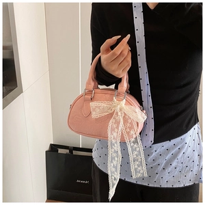 Detailed close-up of pink lace bowling bag with embossed animal pattern and ribbon bow